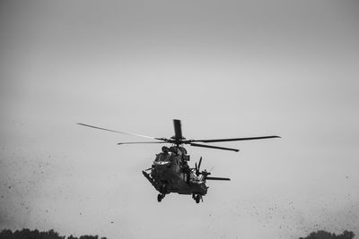 Low angle view of helicopter flying against sky