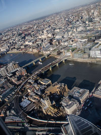 Aerial view of river amidst buildings in city on sunny day