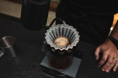 High angle view of hand holding tea cup on table