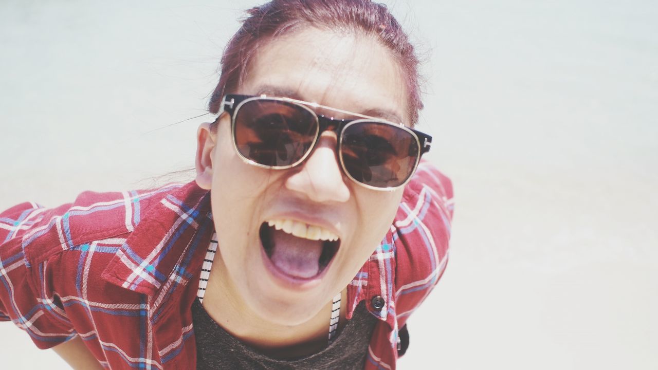 CLOSE-UP PORTRAIT OF YOUNG WOMAN IN SUNGLASSES