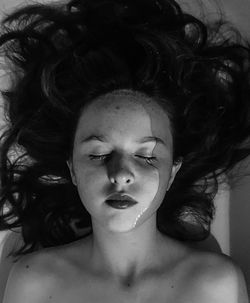 Directly above shot of topless young woman with eyes closed in bathtub