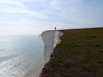 Scenic view of person on cliff against sky