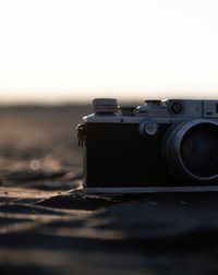 Close-up of camera on road against clear sky during sunset