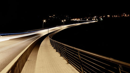 Light trails on bridge in city at night