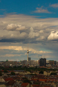 High angle view of city buildings against cloudy sky