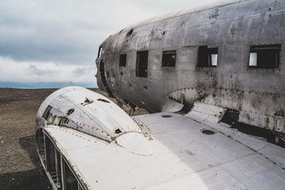 Abandoned airplane on airport runway against sky