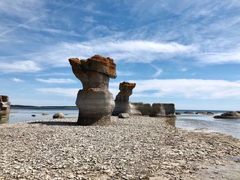 Rocks on beach against sky