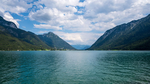 Scenic view of lake by mountains against sky