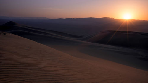 Scenic view of desert against sky during sunset