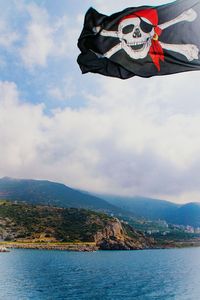 Scenic view of sea and mountains against sky