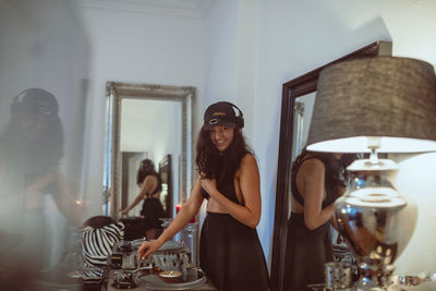 Fashionable young woman playing music at home