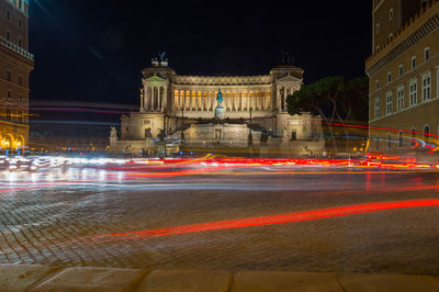 Light trails on fountain in city at night