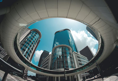 Low angle view of skyscrapers against cloudy sky