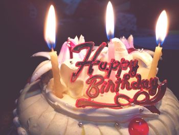 Close-up of burning candles on cake