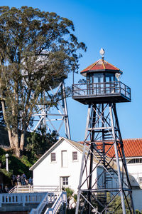 Tower by building against clear blue sky