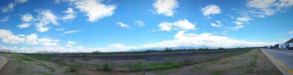 Road on field against cloudy sky