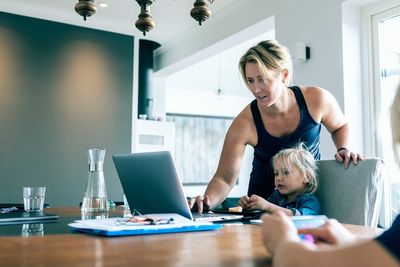 Woman looking at camera while sitting on table