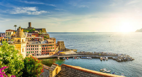 Scenic view of sea by buildings against sky