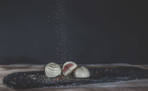 Close-up of cake on table against black background