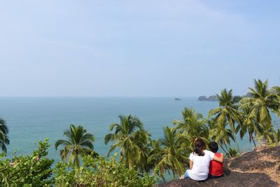 Rear view of man looking at sea against sky