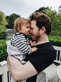 Side view of father embracing daughter on rooftop