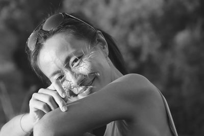 Portrait of woman holding plant sitting outdoors