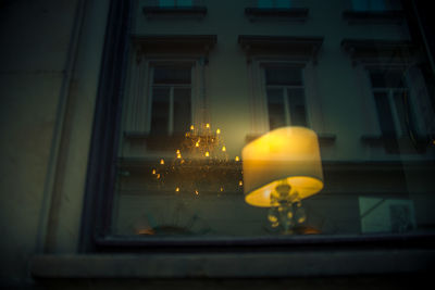 Low angle view of illuminated lamp in building at night