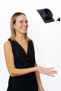 Portrait of young woman standing against white background