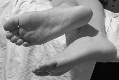 Close-up of person hand on bed at home