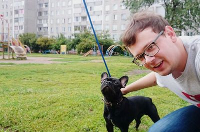 Portrait of man with french bulldog at playground