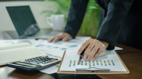 Midsection of businessman working on table