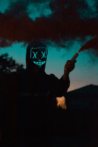 Full length portrait of silhouette man smoking cigarette against sky during sunset