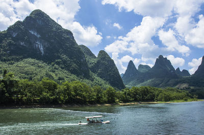 Scenic view of river and mountains against sky