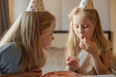 Direct children, caps without hesitation eat birthday, cake hands at home. quarantine, isolation