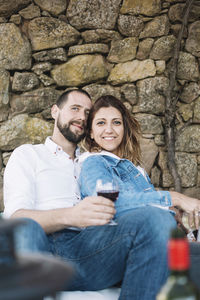Portrait of a smiling young couple sitting outdoors