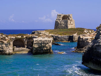 Castle by sea against blue sky