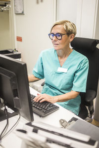 Female pediatrician working on computer while sitting in hospital