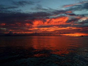 Scenic view of sea against dramatic sky during sunset