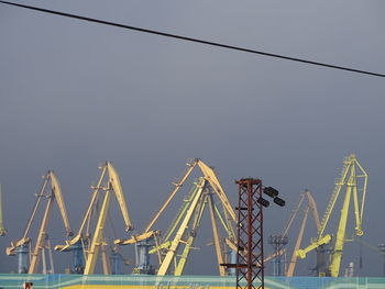 Low angle view of cranes against sky