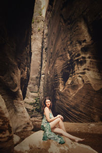 Portrait of woman sitting on rock