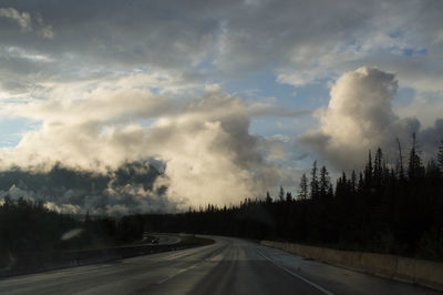 Road amidst trees against sky