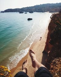 Low section of man standing on beach