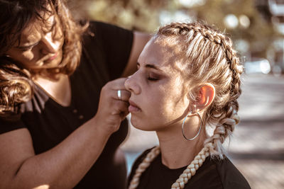 Beautician applying make-up on customer face