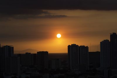 Silhouette buildings against sky during sunset