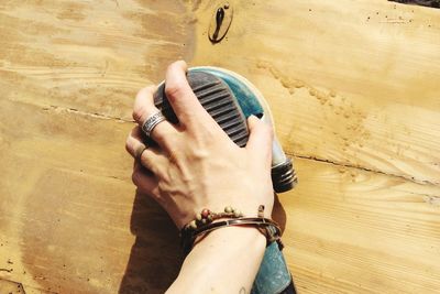 Man hand moving sander on wood material