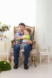 Young man sitting on chair at home