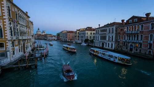 Boats in canal amidst buildings in city