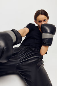 Portrait of teenage girl exercising against white background