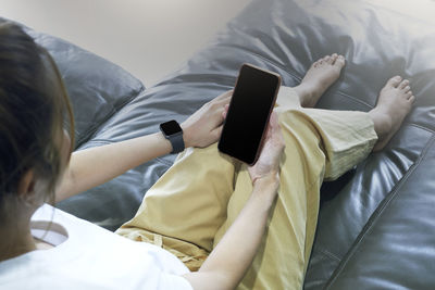 High angle view of siblings lying on bed at home