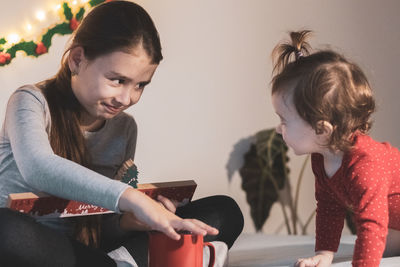 Two girls with an advent calendar on the bed.